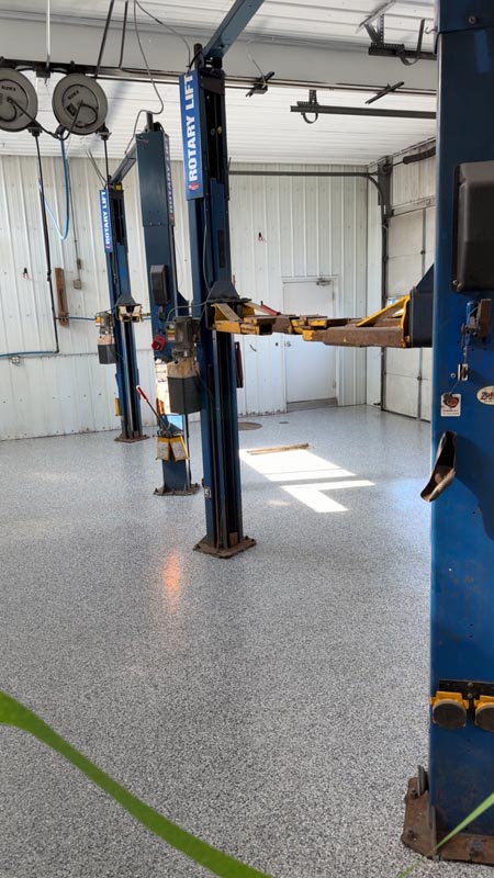 Mechanic shop with finished grey flake floor and blue Rotary Lift hoists